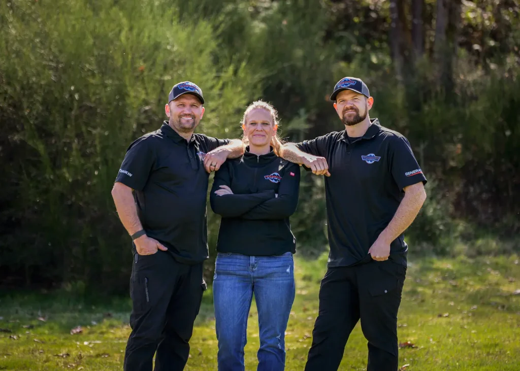 Three team members posing outdoors.