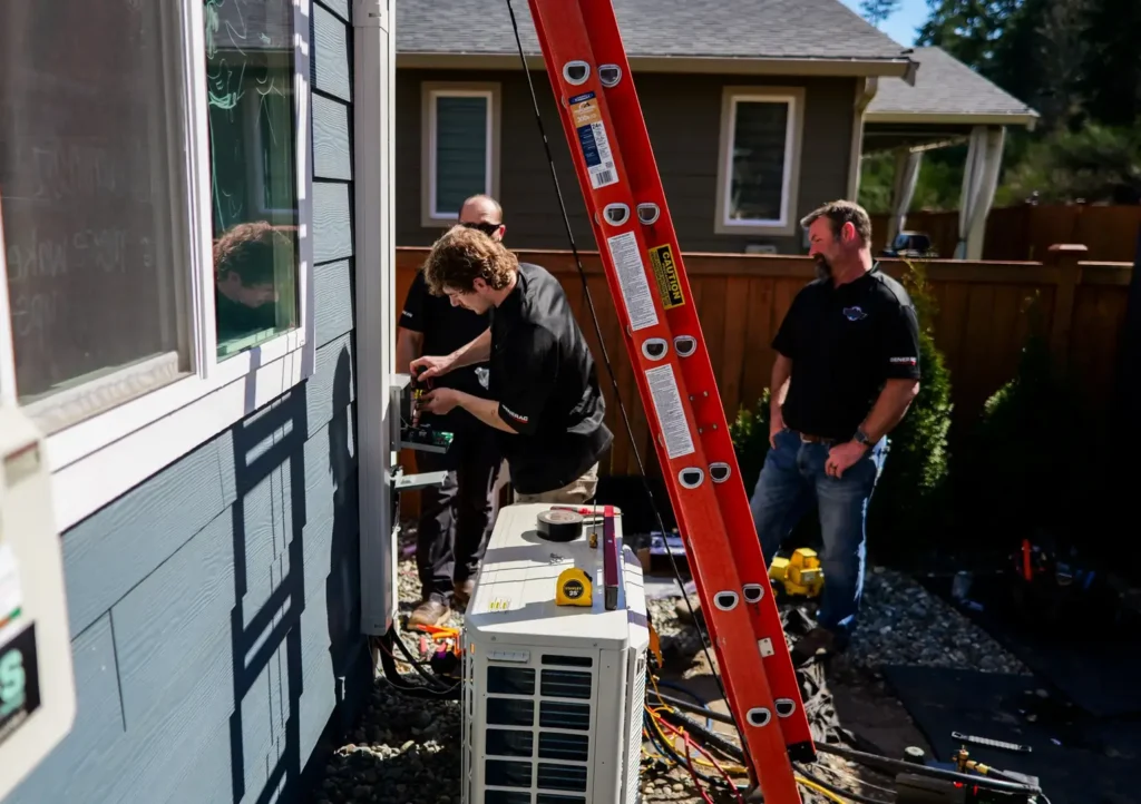 Technicians installing equipment outside a house