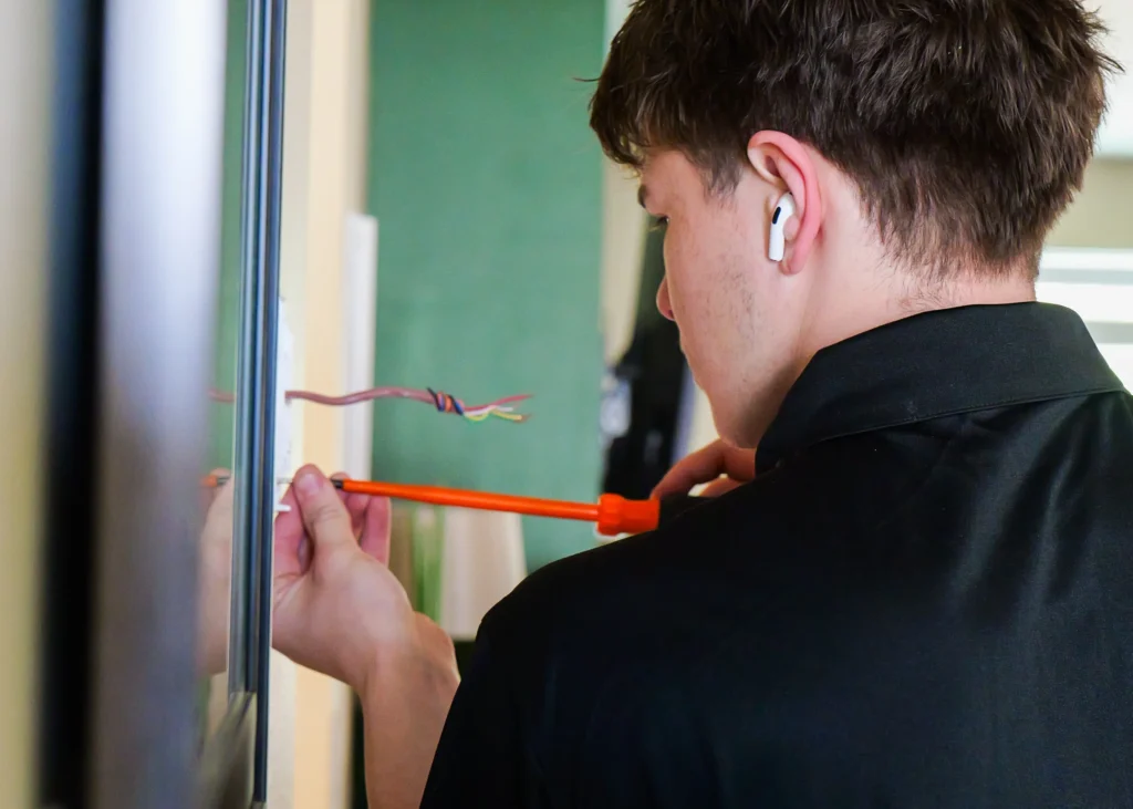 Technician measuring an indoor equipment installation.